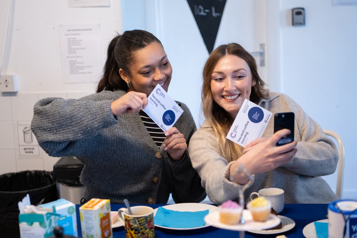 A photo of two Cancer Research UK volunteers at a bake sale.