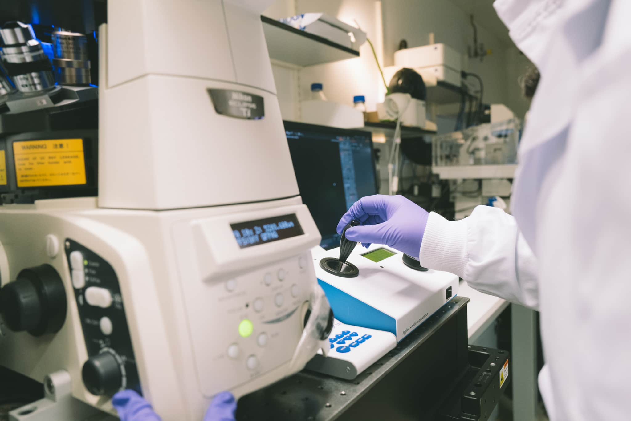 Hand shot of researcher working on a lab equipment. Cambridge lab with our researchers working alone.