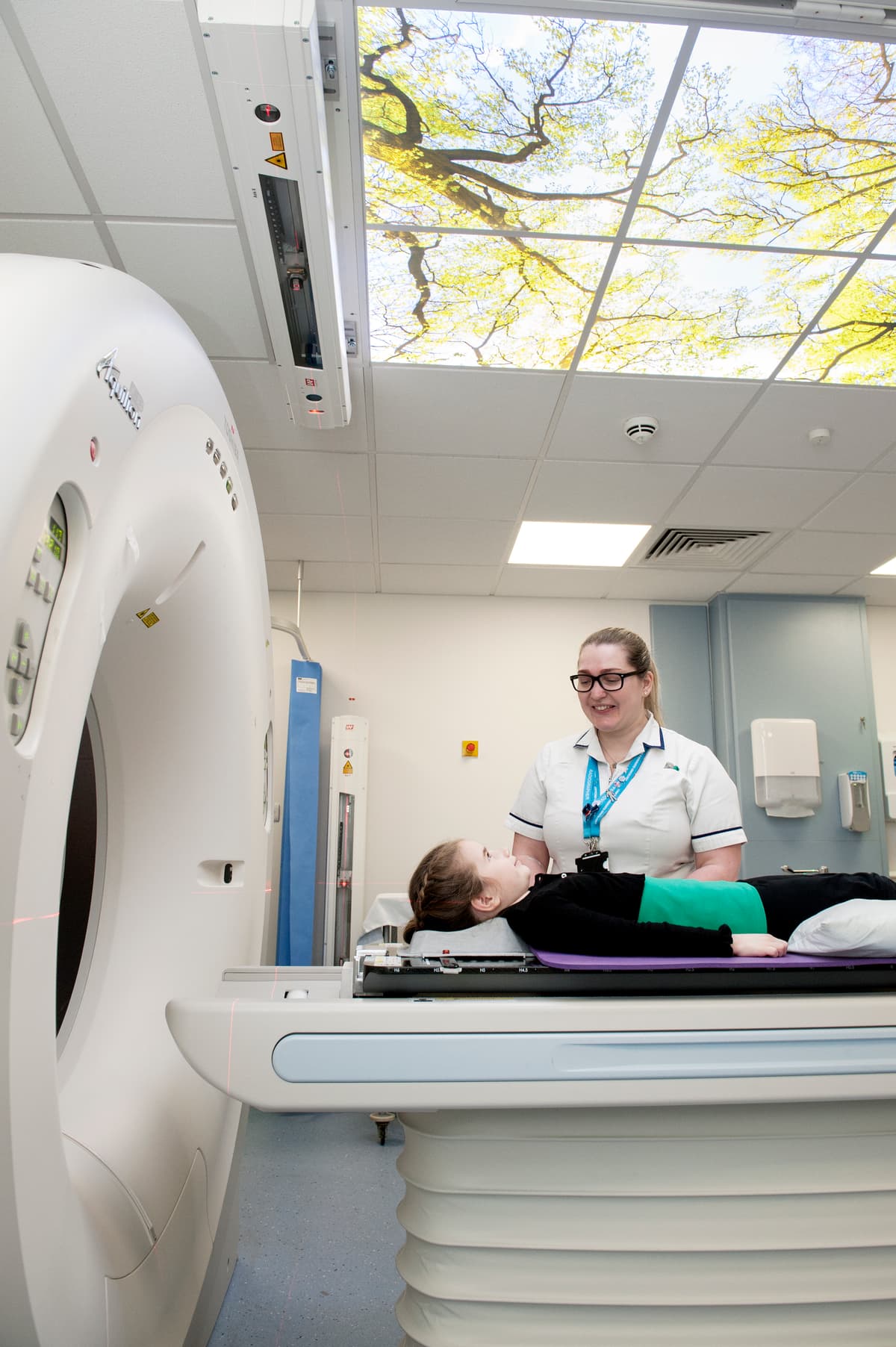 Photograph of a child, radiographer and radiotherapy machine.