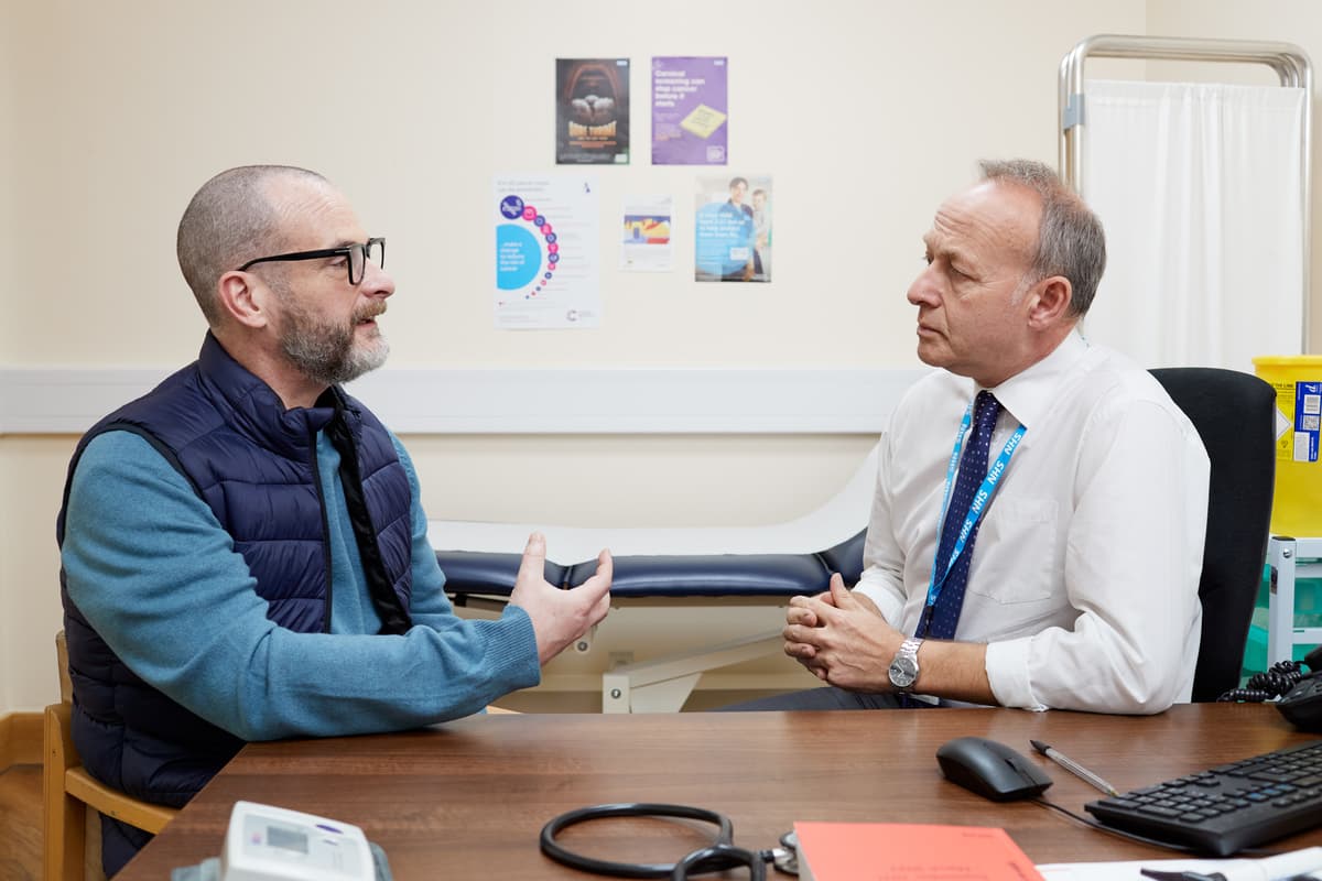 This photo shows a patient having a conversation with a GP about possible bowel cancer symptoms.