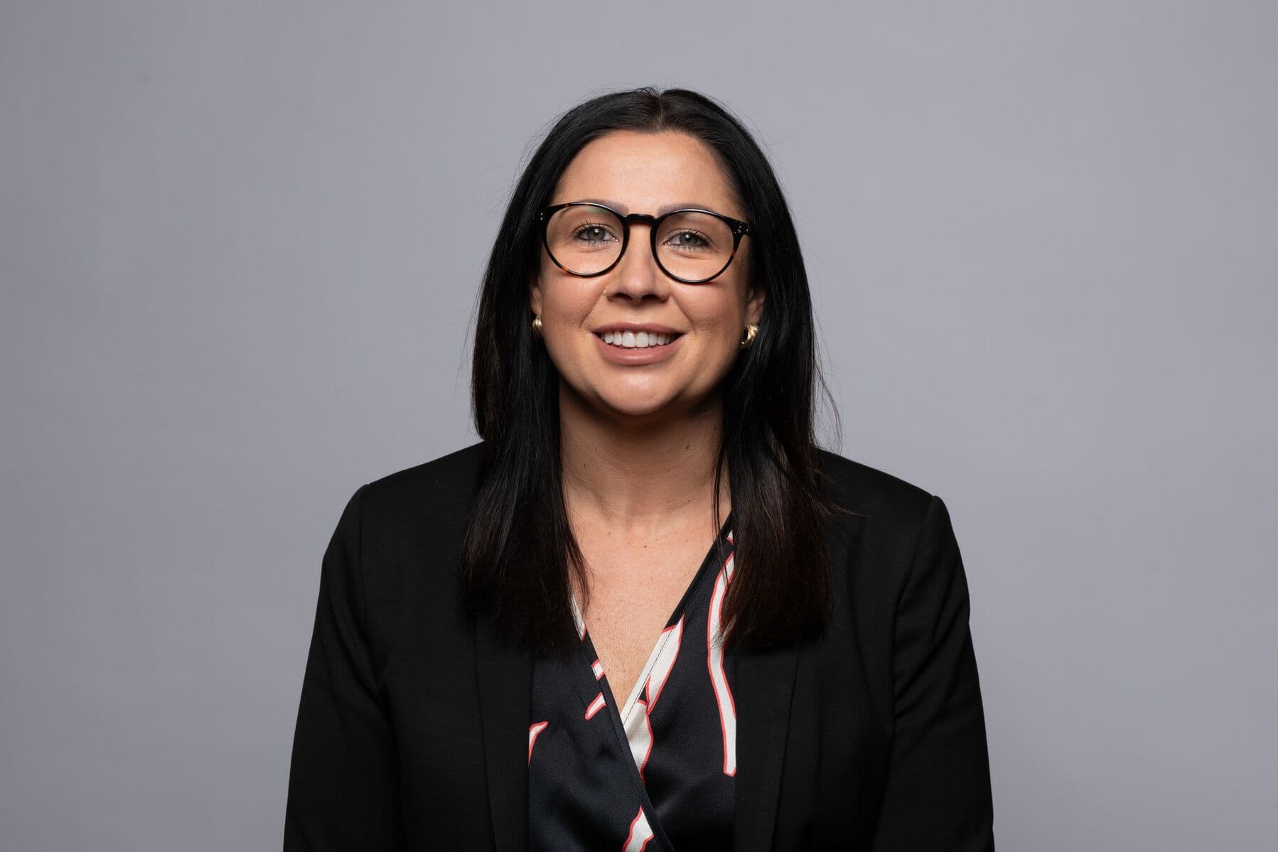 A smartly dressed businesswoman smiling.