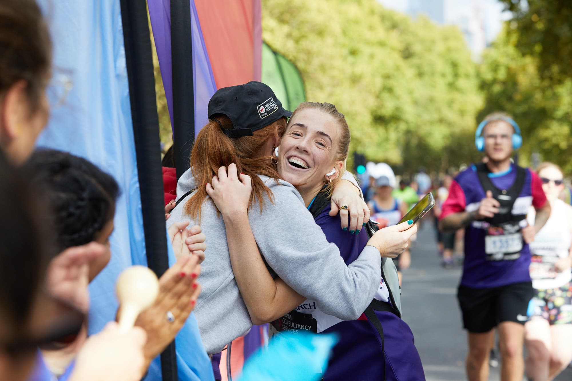 Two people hugging each other at a marathon.