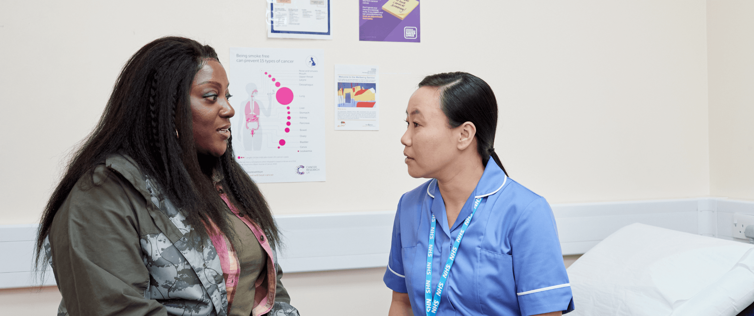 Photo of a patient and health professional talking in a treatment room.