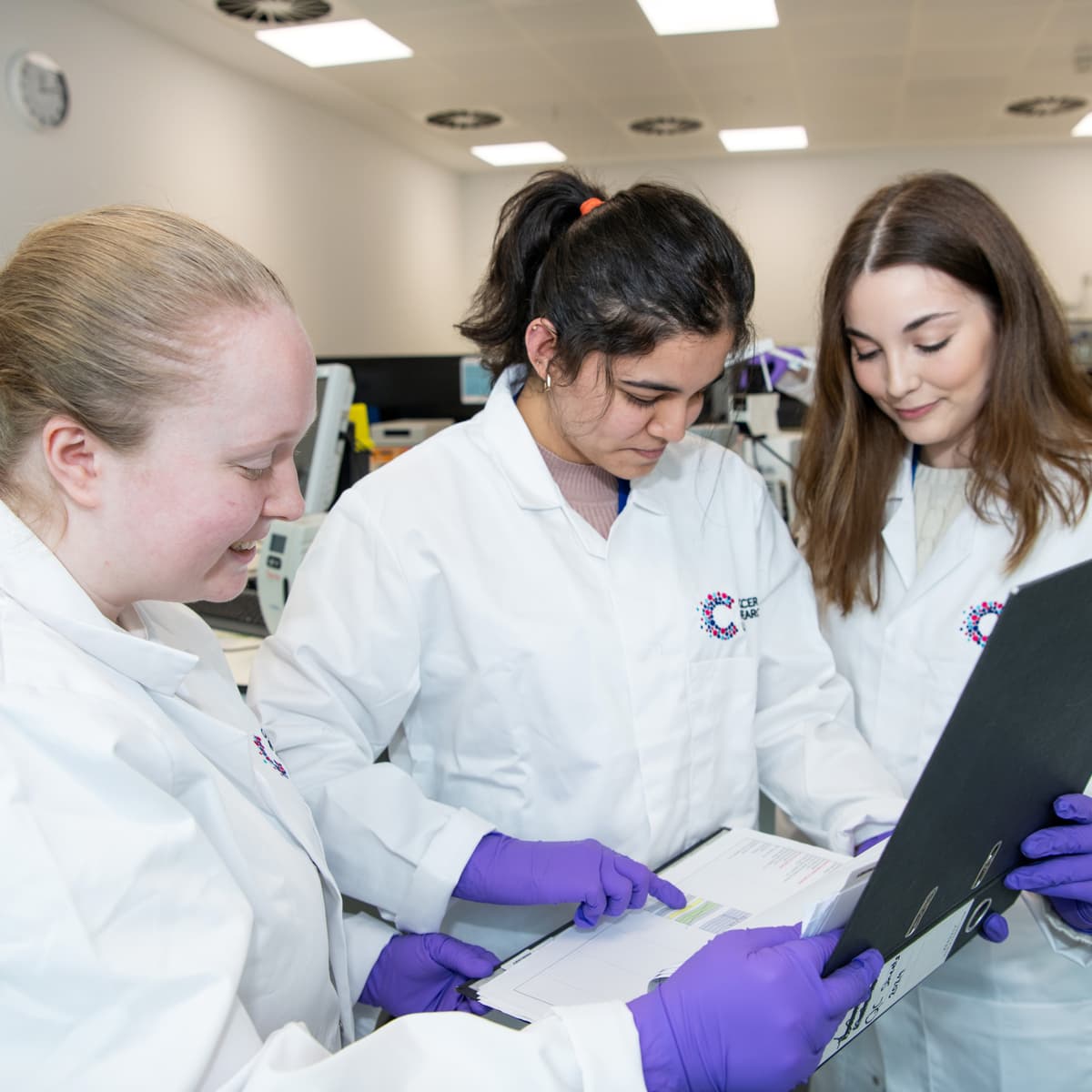 Three researchers looking at a file.