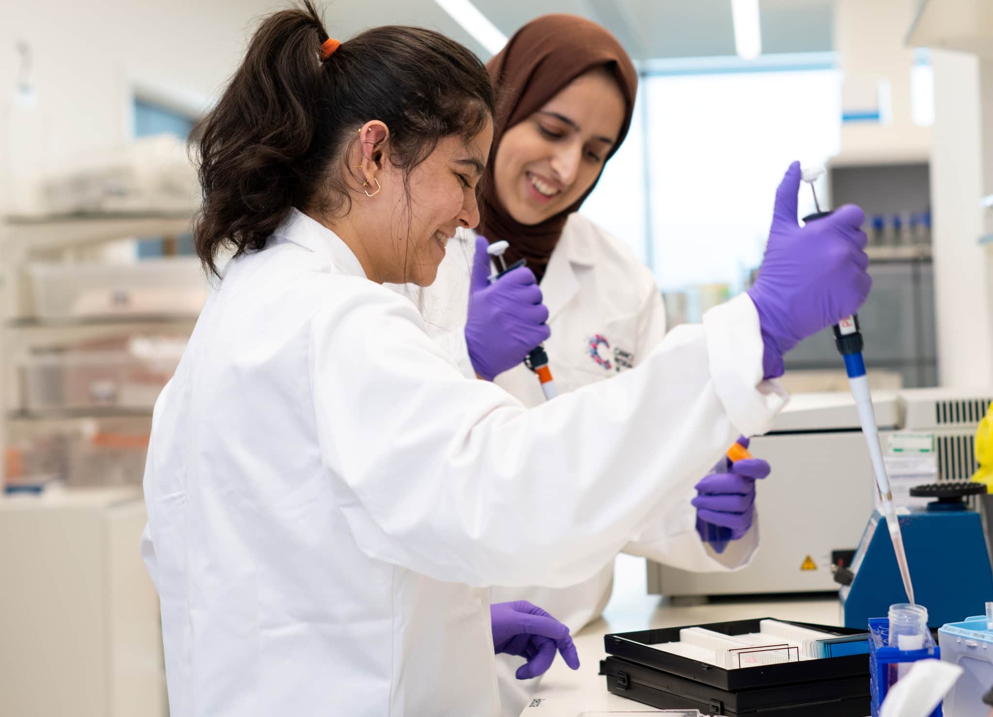 Researchers smiling and working in the lab.