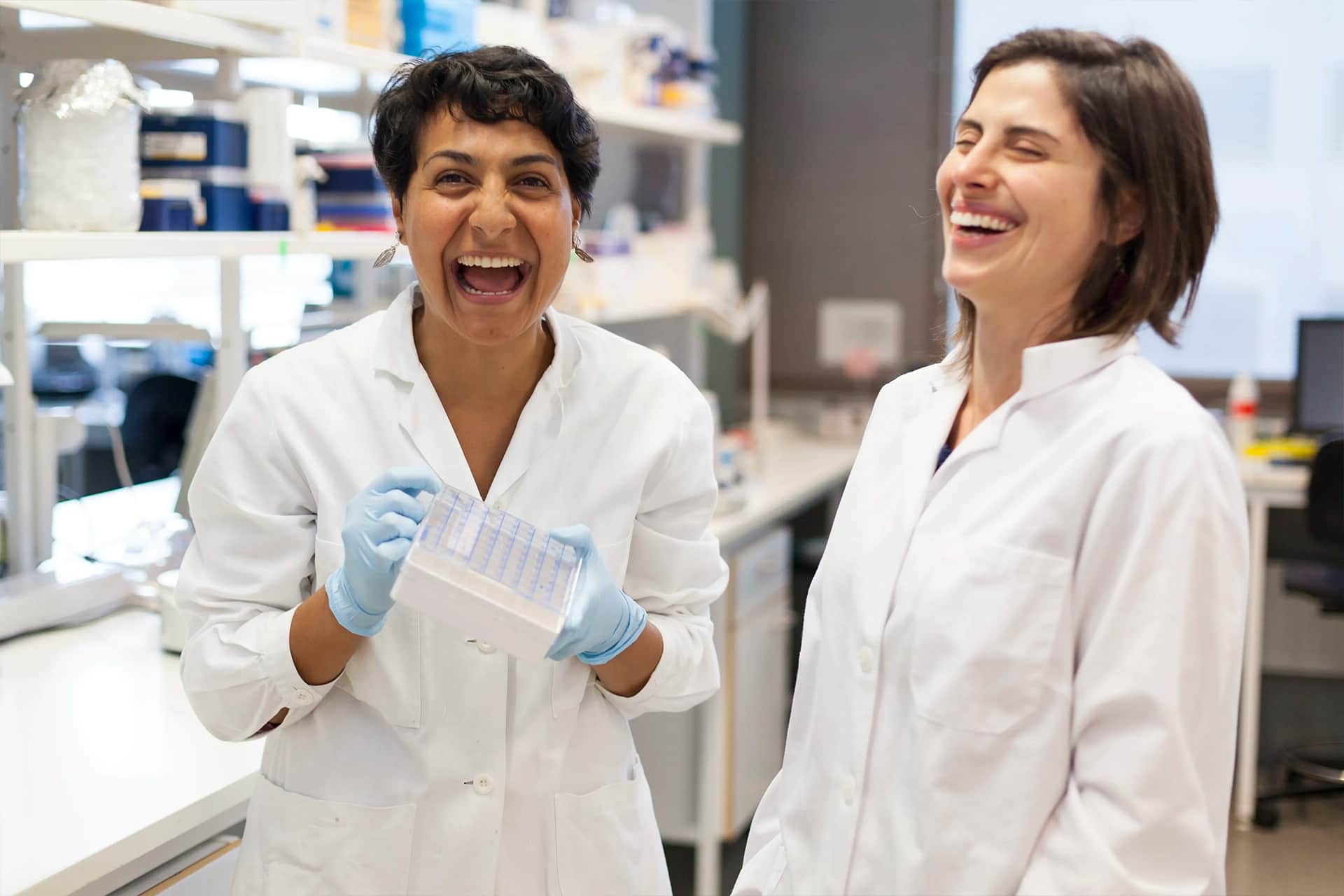 A photo of two women in lab coats smiling.