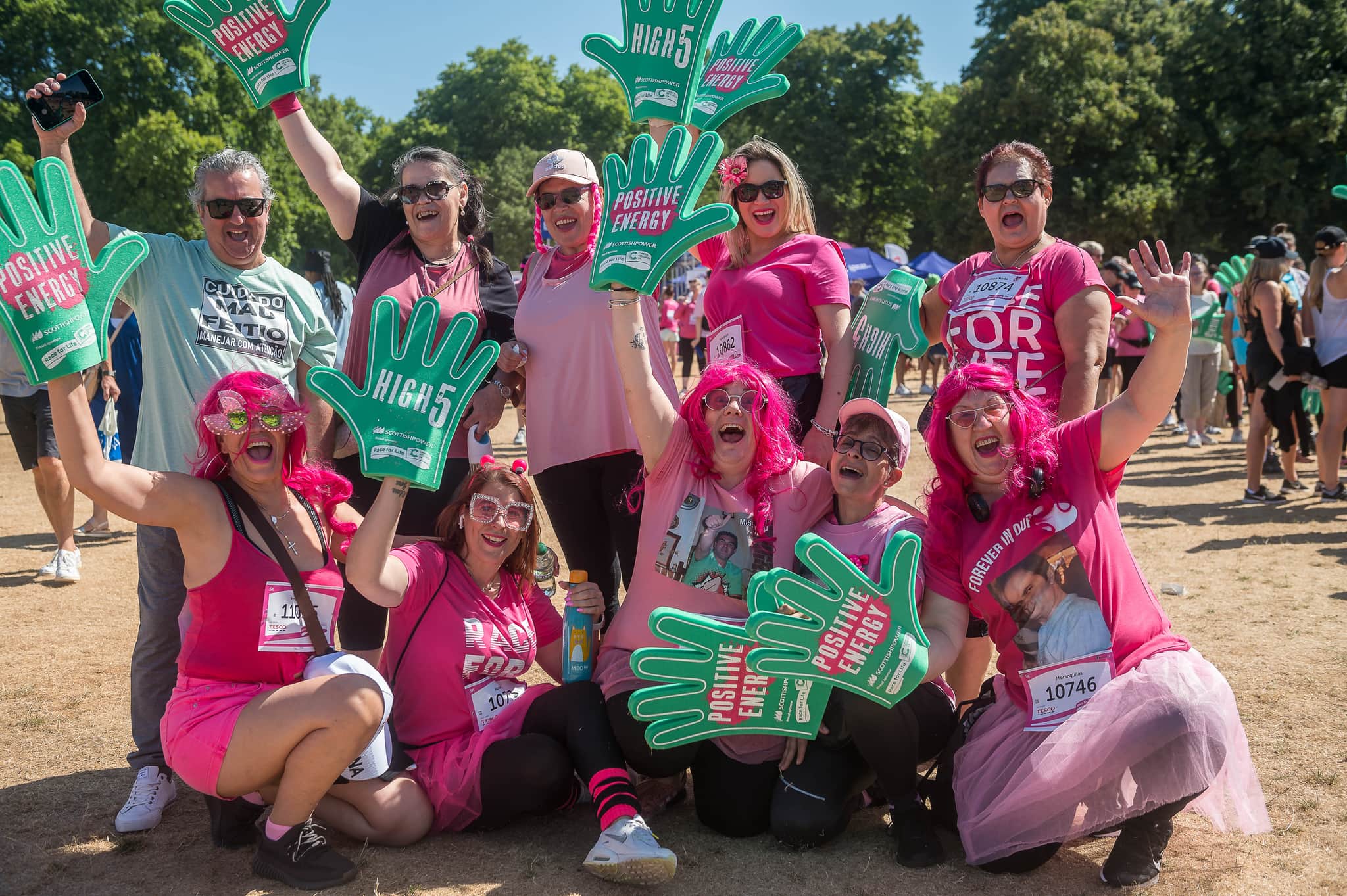 A group of people celebrating at a Cancer Research UK event. It's sunny and they look happy.