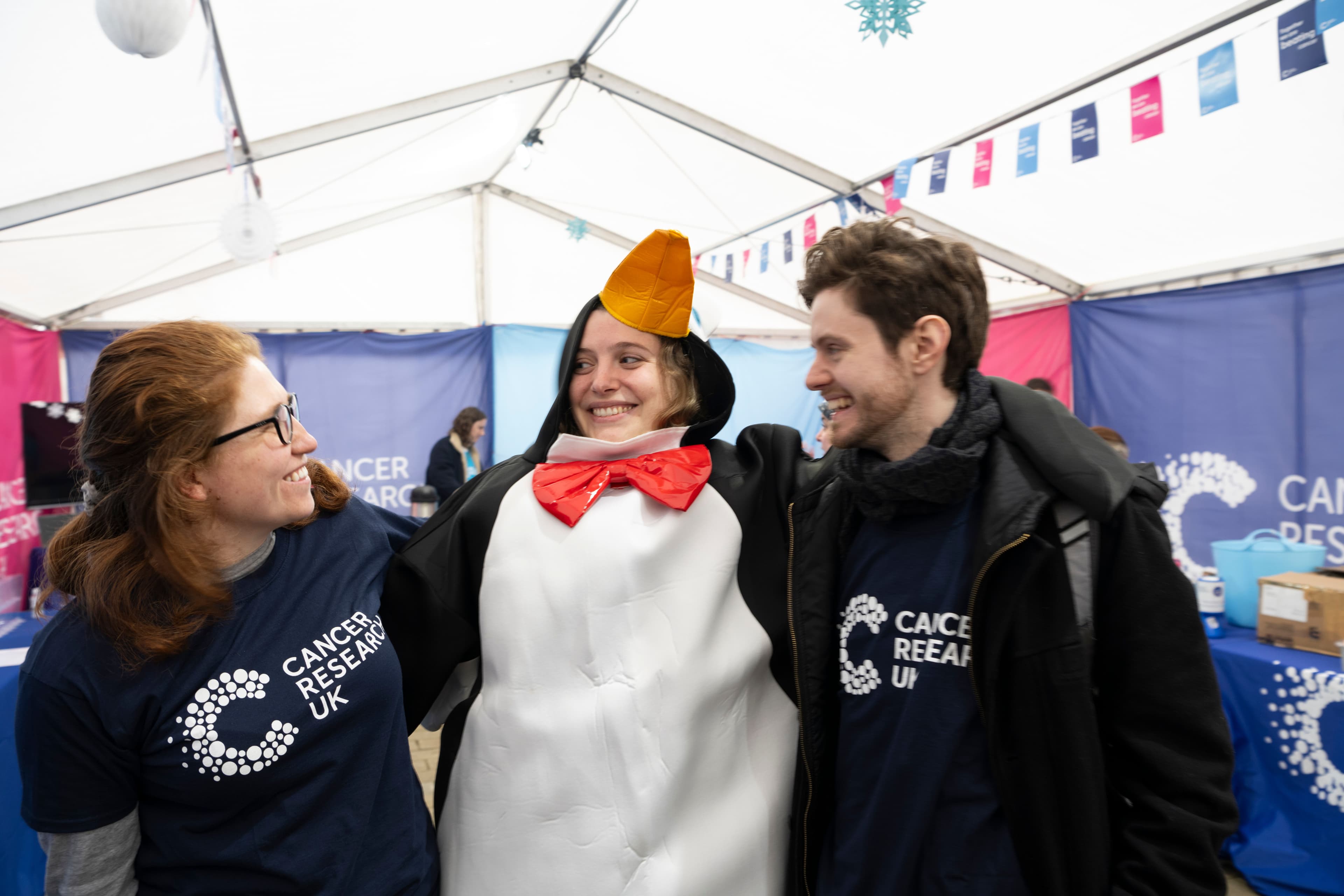 Three volunteers smiling at each other.