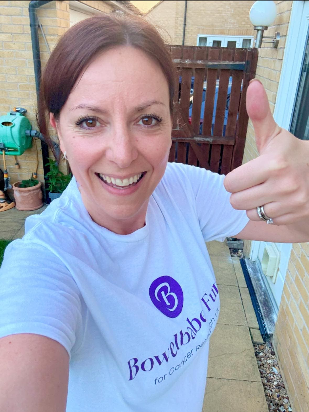 Picture of a women in a Bowelbabe Fund t-shirt with her thumbs up.