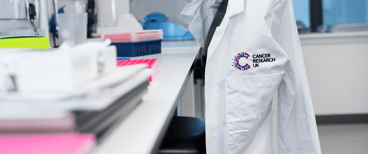 A lab coat hung on the back of a desk chair at the Cancer Research UK Scotland Institute.