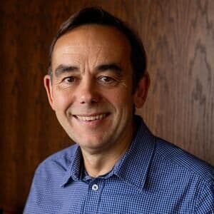 A smartly dressed man smiling.