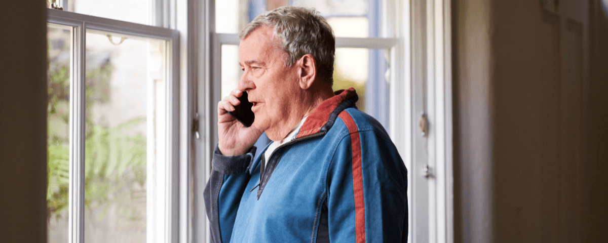 A patient looks out the window while talking to a health professional on the phone.