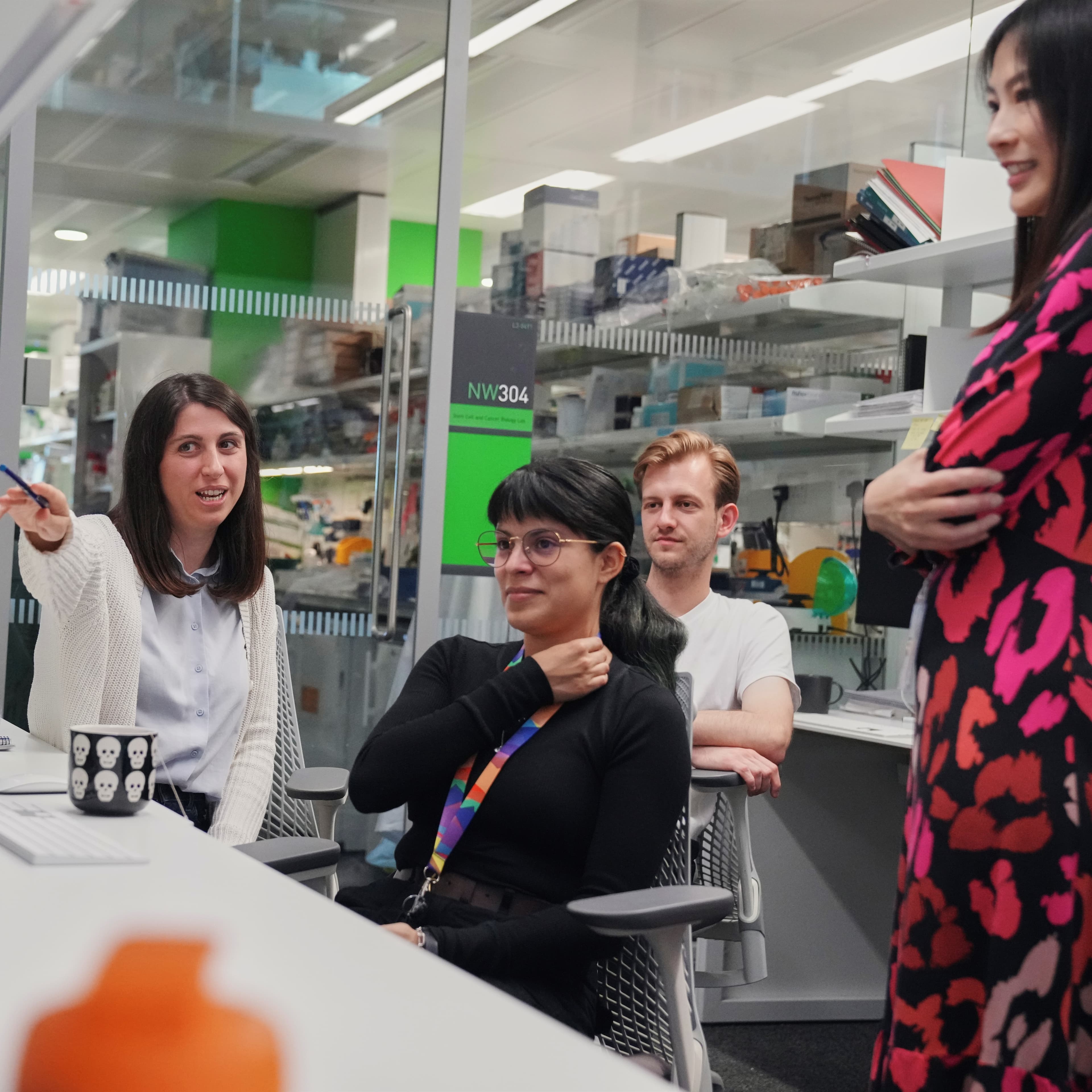 A group of people looking at a computer in the lab.