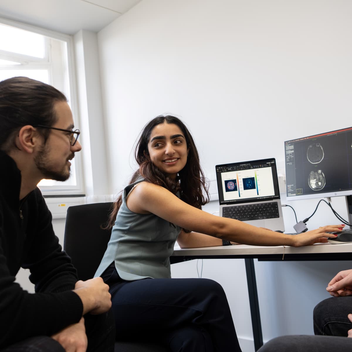 Researchers discussing brain images at a desk.