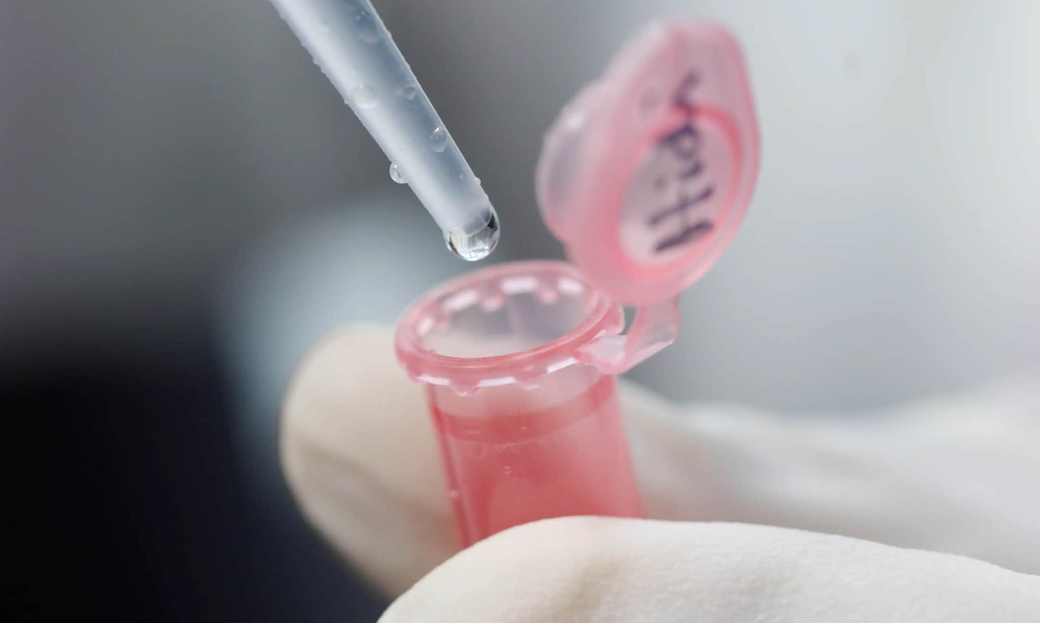 A pipette dropping a clear liquid into a test tube.