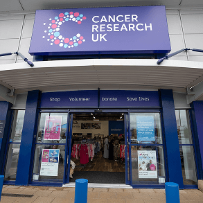 A photo of a person entering a Cancer Research UK shop.