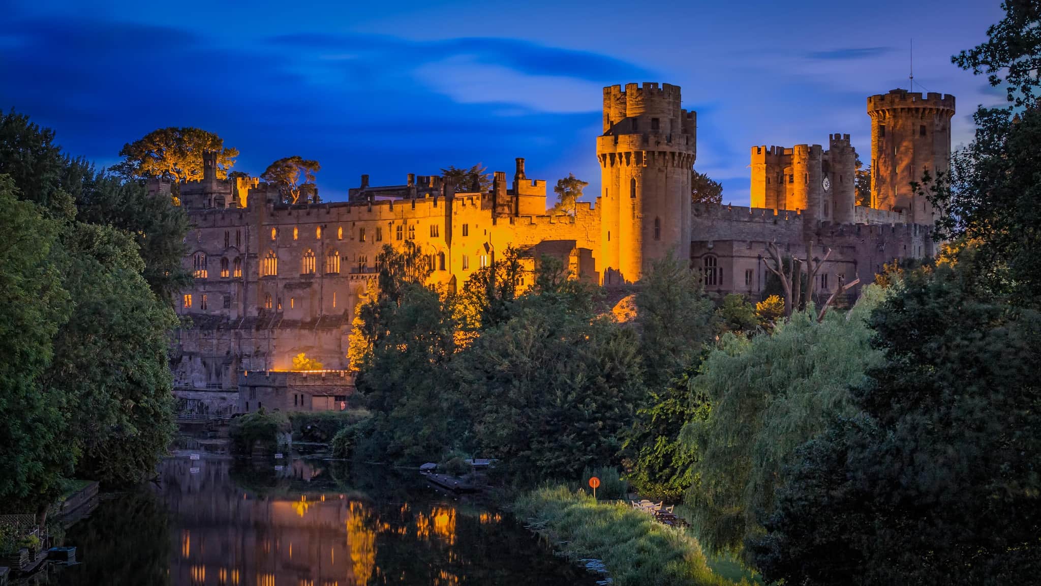 A view of Warwickshire castle lit up at night.