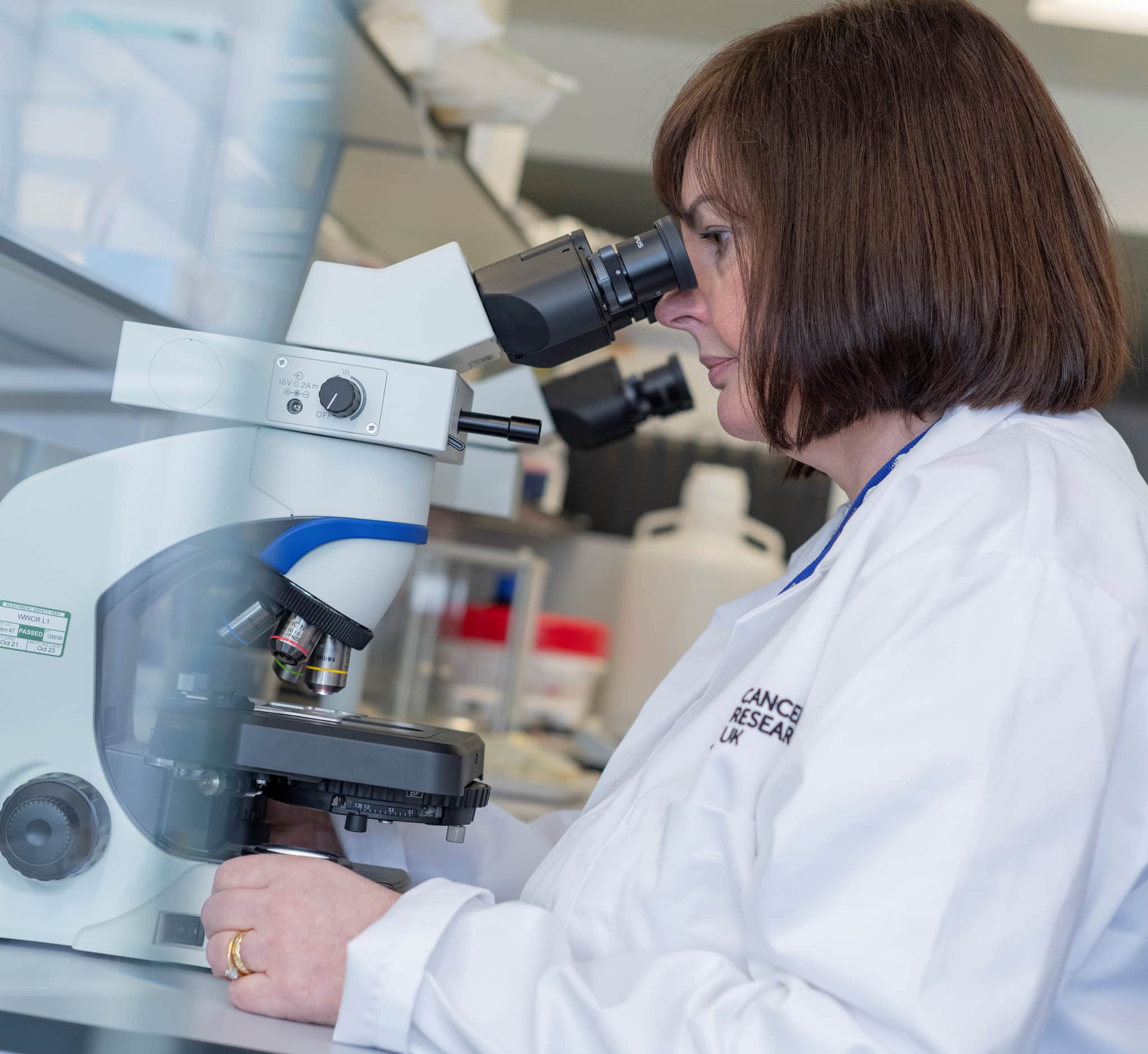 A researcher looking through a microscope.